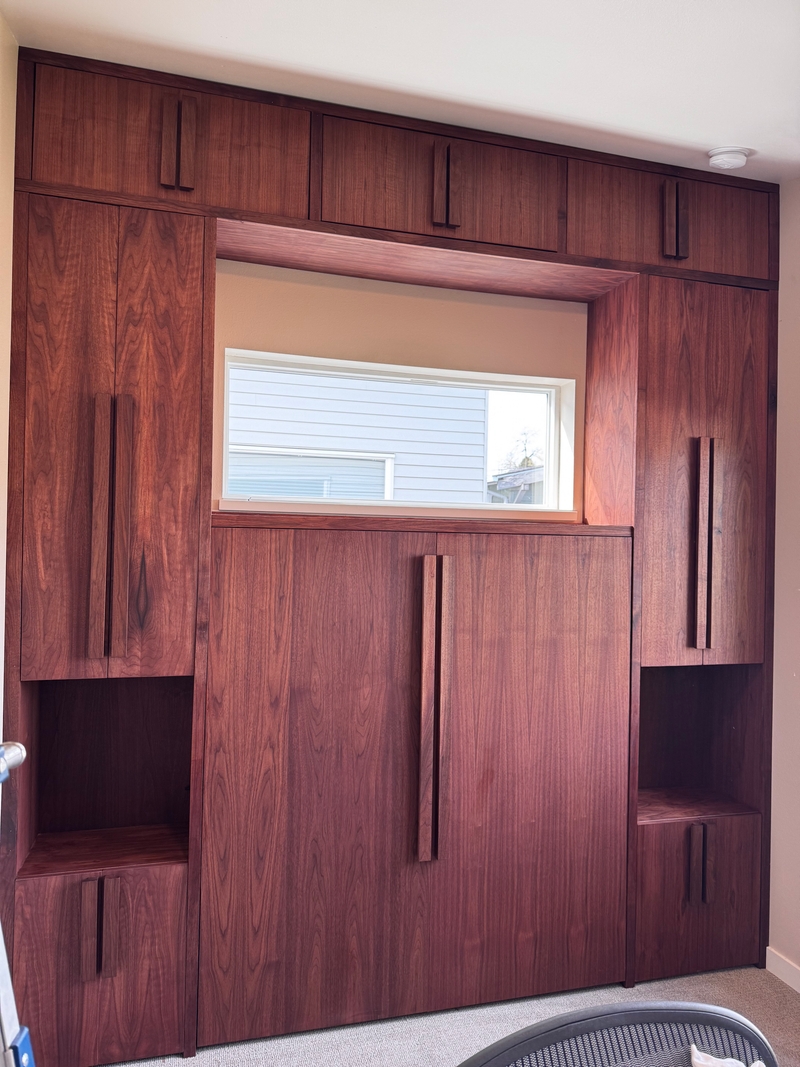 Walnut murphy bed with surrounding cabinets